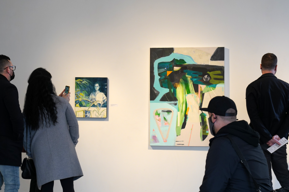 people look at two paintings on a white wall
