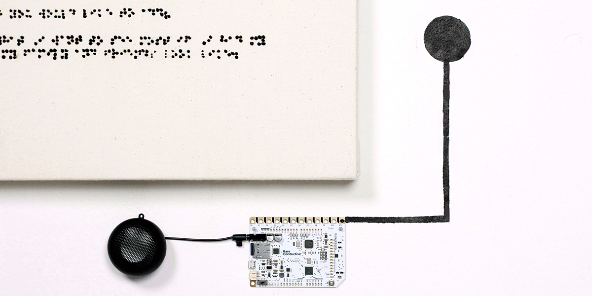  A close up of the touch board computer connected to a speaker and the conductive paint, indicating a spot to touch to activate the audio recording of the interview painted in Braille.