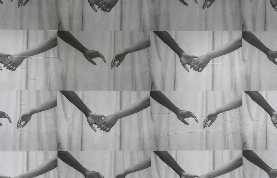 The image is a wheatpaste installation called "Connection" by the artist Cruz. The work is a series of photos printed in greyscale on poster paper. The photos depict a pair of arms reaching out for an embrace, with each poster representing a new progression of the motion.